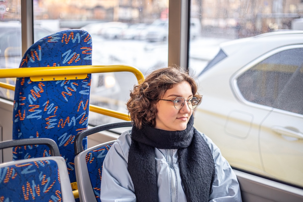 kobieta patrząca przez okno w autobusie miejskim kobieta jadąca autobusem