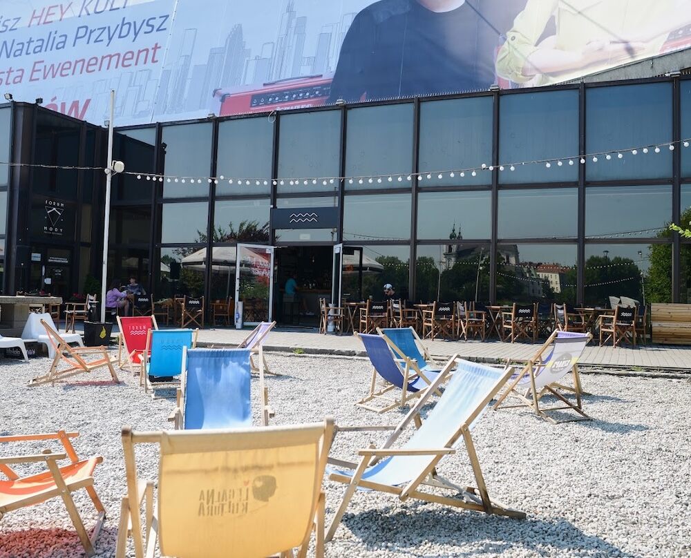 Hotel Forum Kraków z kolorowymi leżakami pod budynkiem Hotel Forum Kraków z leżakami na kamieniach