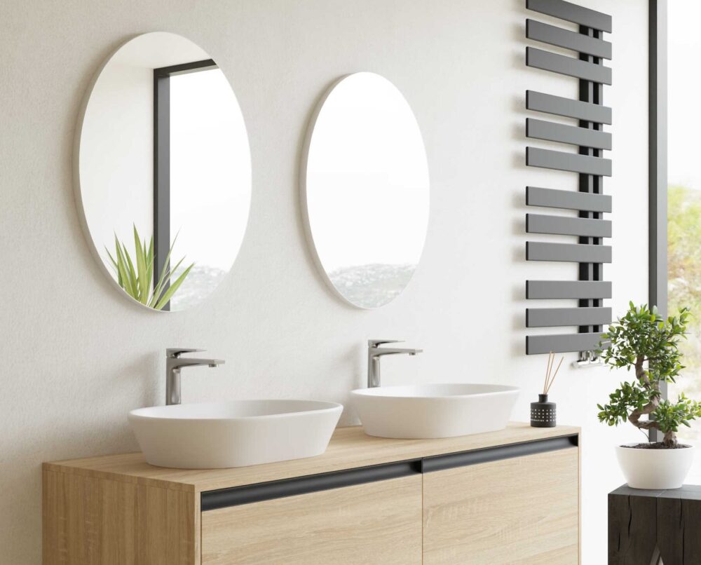 dwie umywalki z okrągłymi lustrami