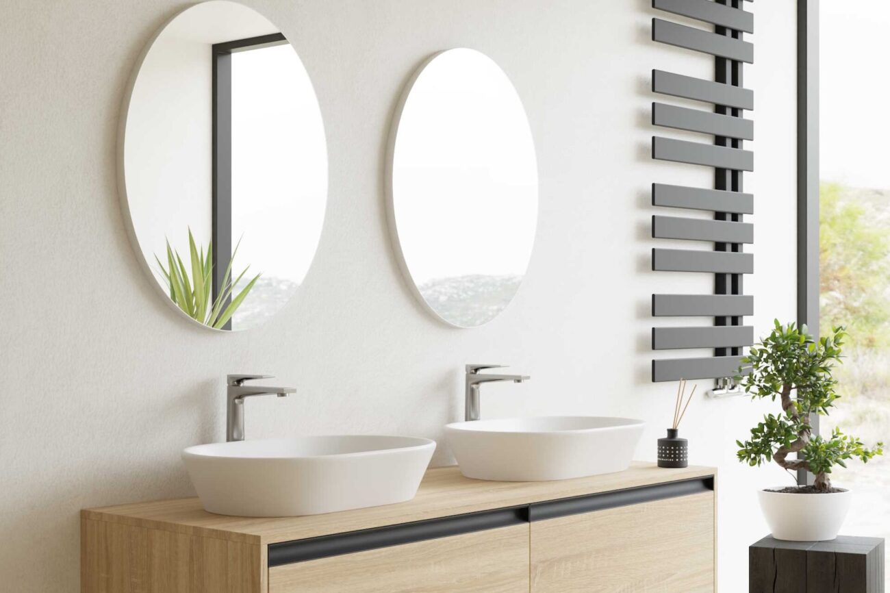 dwie umywalki z okrągłymi lustrami