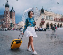 dziewczyna z parasolem idąca przez krakowski rynek
